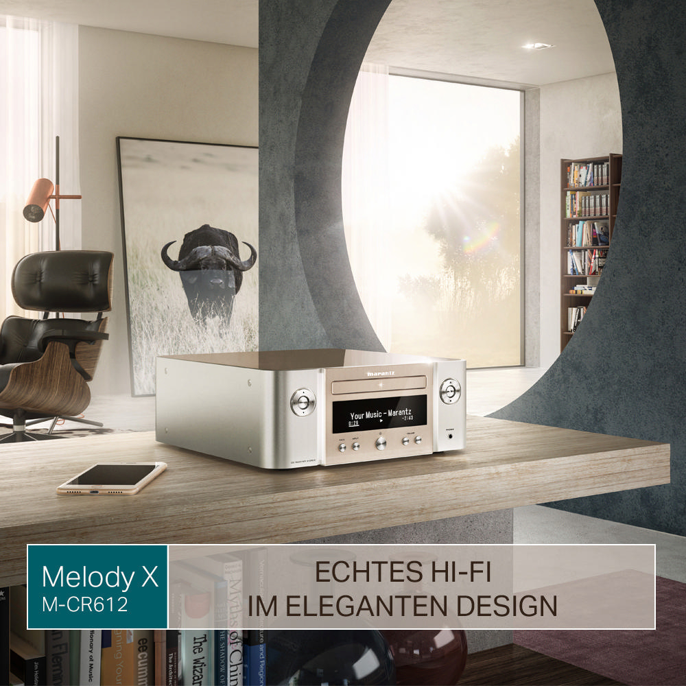 Hi-Fi-System auf einem Tisch. Hintergrund: Fenster, Bücherregal. Text auf Deutsch.