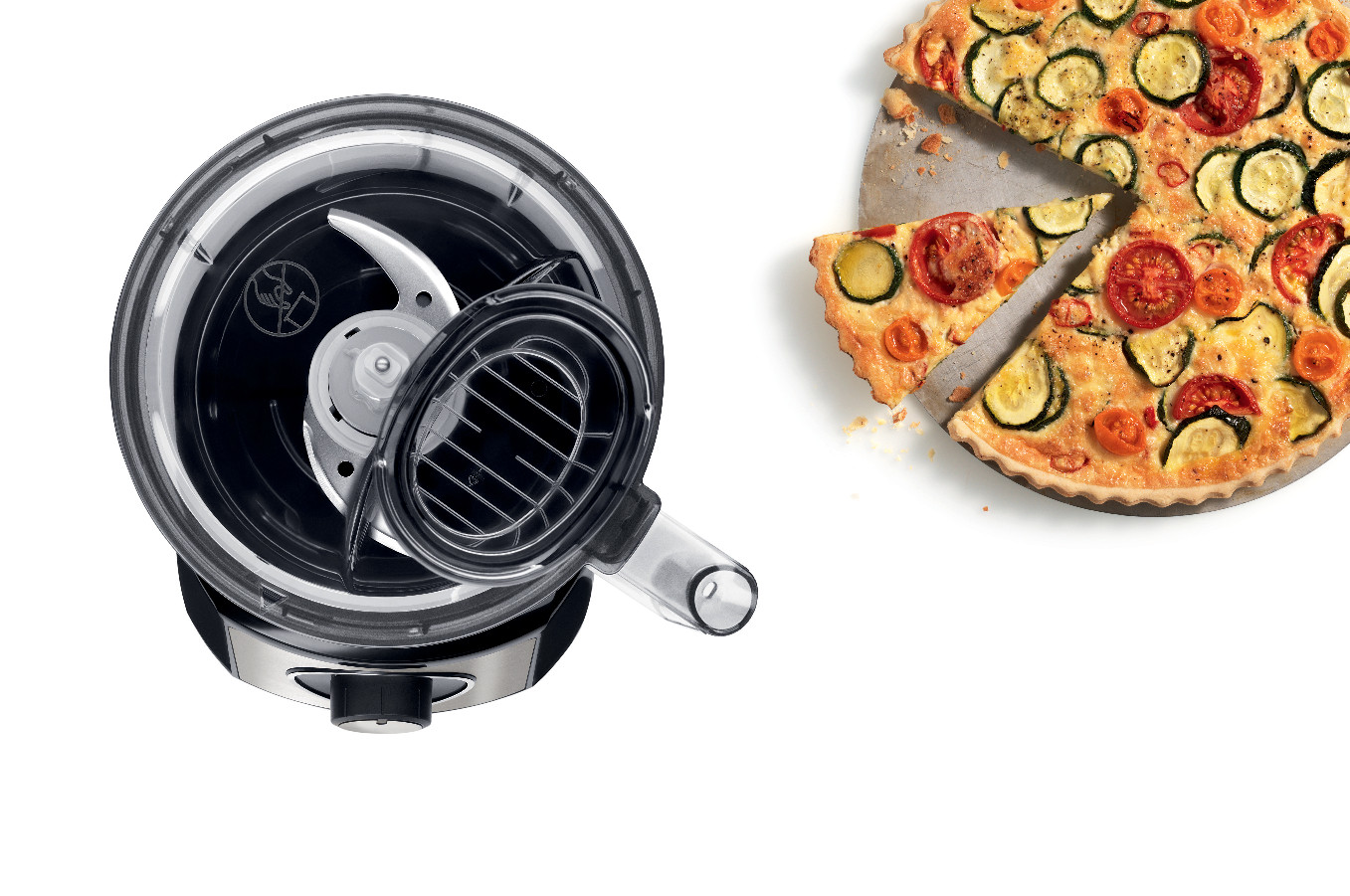Food processor with a pizza in the background, top view.