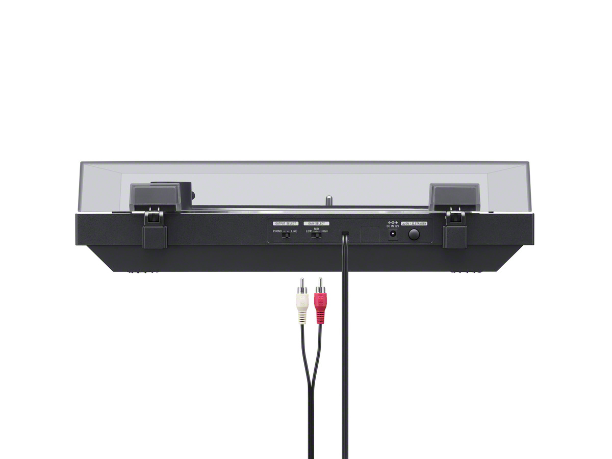 Turntable's back with RCA cables and power input, black body, clear cover, on white.