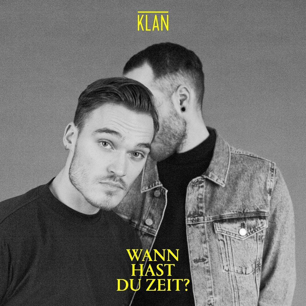 Albumcover mit zwei Männern eng beieinander, einer schaut in die Kamera. Gelber Text auf grauem Grund.