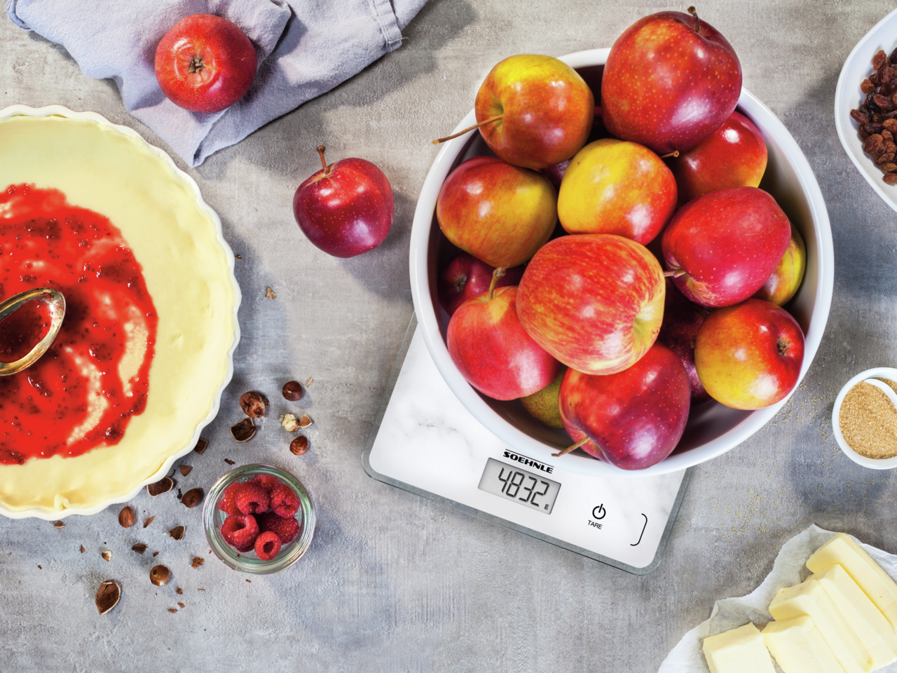 Balance avec pommes, pâte à tarte, framboises et ingrédients. 483,2g.