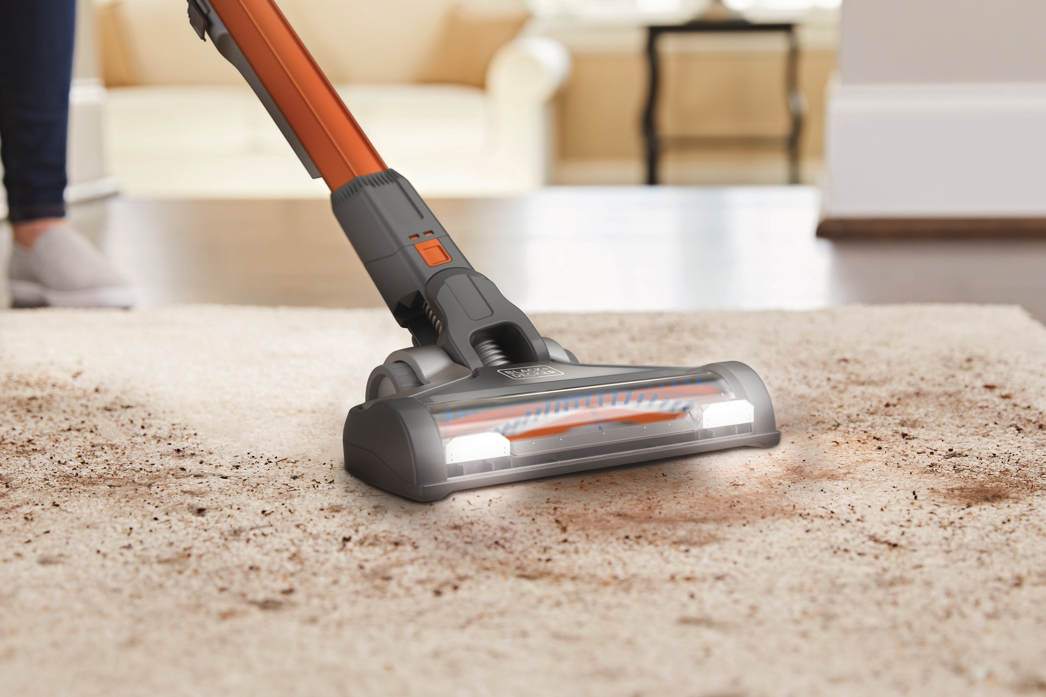 Staubsaugerkopf reinigt einen beigen Teppich, zeigt Schmutz und die Marke Black+Decker.