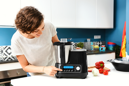 Mujer usando una máquina de cocina negra en una cocina.