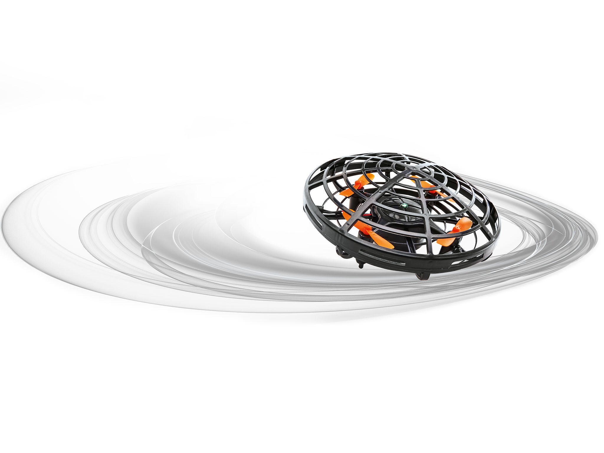 Eine schwarze Drohne mit orangefarbenen Rotorblättern fliegt in der Luft vor weißem Hintergrund.