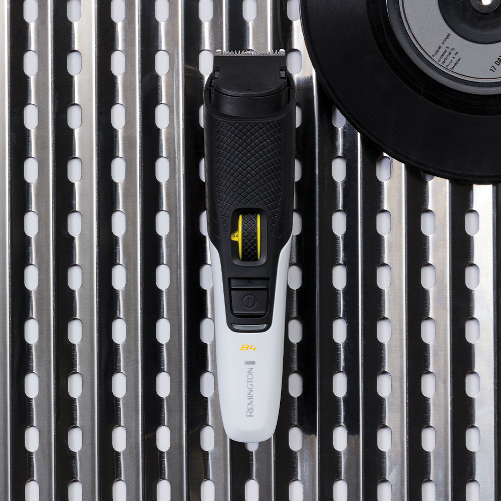 White and black Remington beard trimmer on a metallic surface.