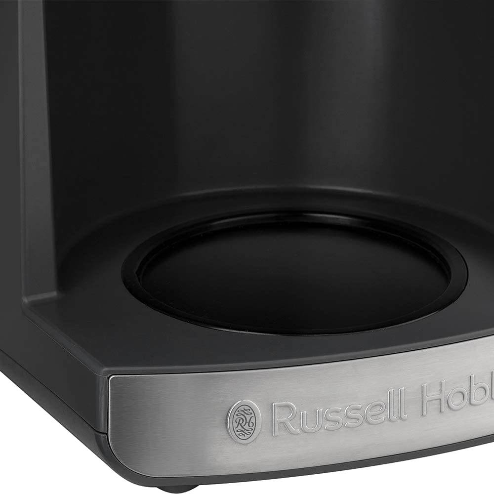 Közeli kép egy fekete kávéfőző aljáról, egy ezüst Russell Hobbs márkájú táblával.