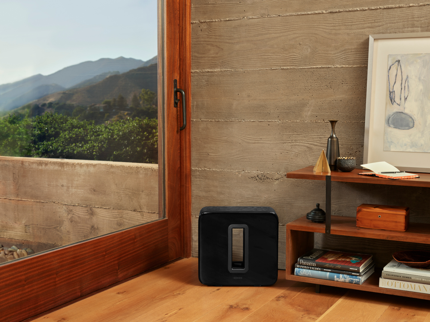 Zwarte subwoofer naast een raam.