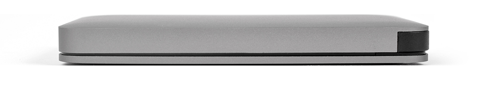 A gray, rectangular device, viewed from the side, rests on a white surface.