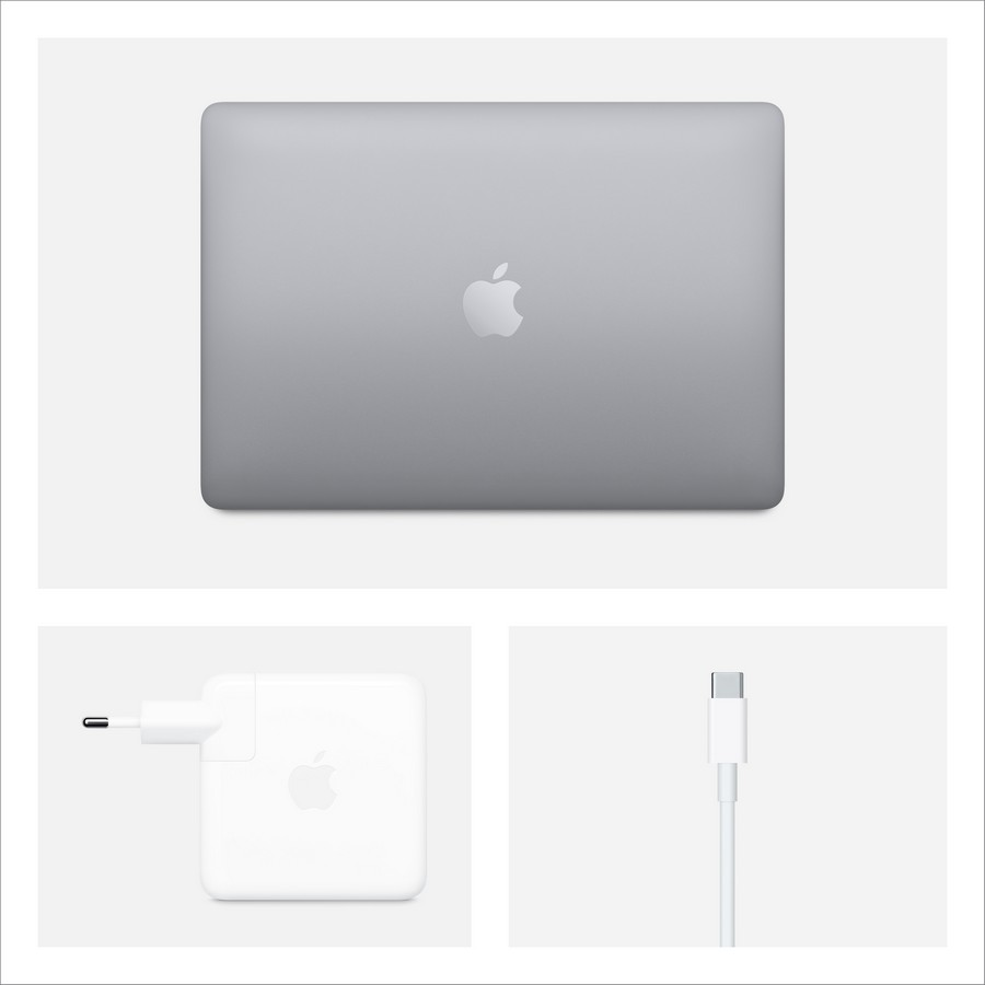 Vista superior de un portátil MacBook, adaptador de corriente y cable de carga sobre una superficie blanca.
