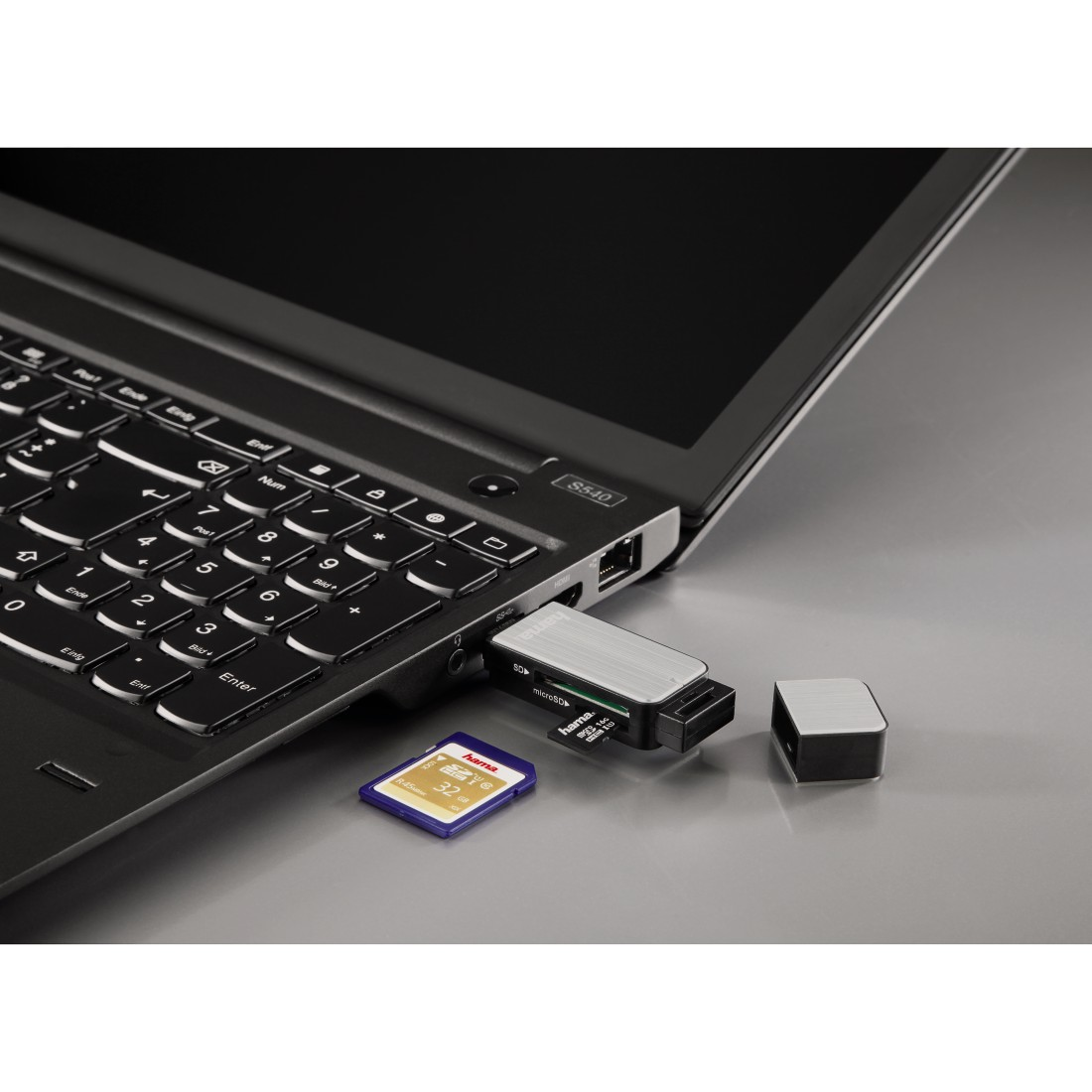 Laptop mit SD-Kartenleser und eingelegter SD-Karte. Schwarzer Hintergrund.