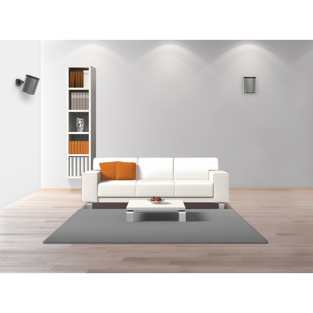 Ein Wohnzimmer mit weißem Sofa, Teppich und einem Schrank mit Büchern.