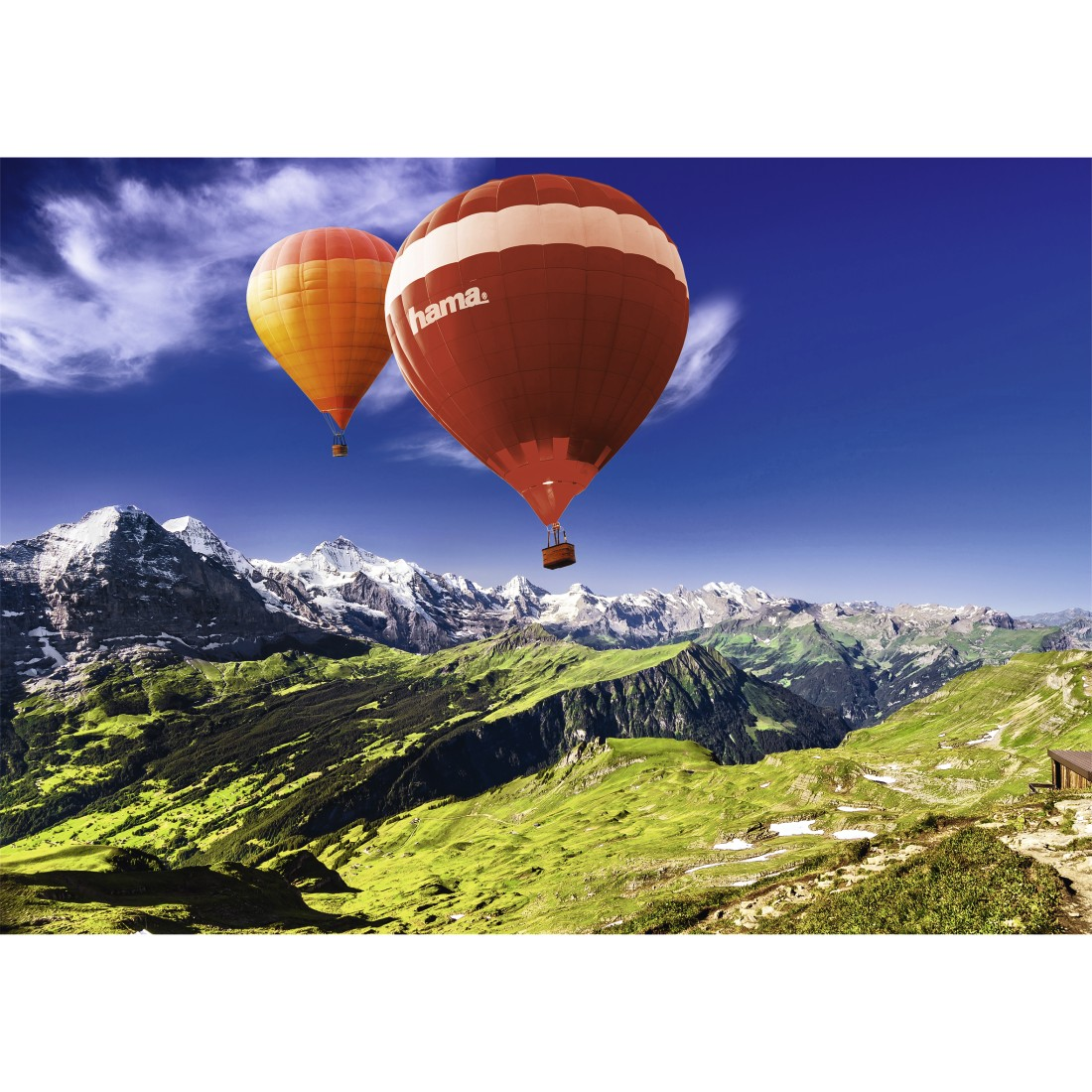 Zwei Heißluftballons über einem Gebirge. Orange und rote Ballons vor blauem Himmel.