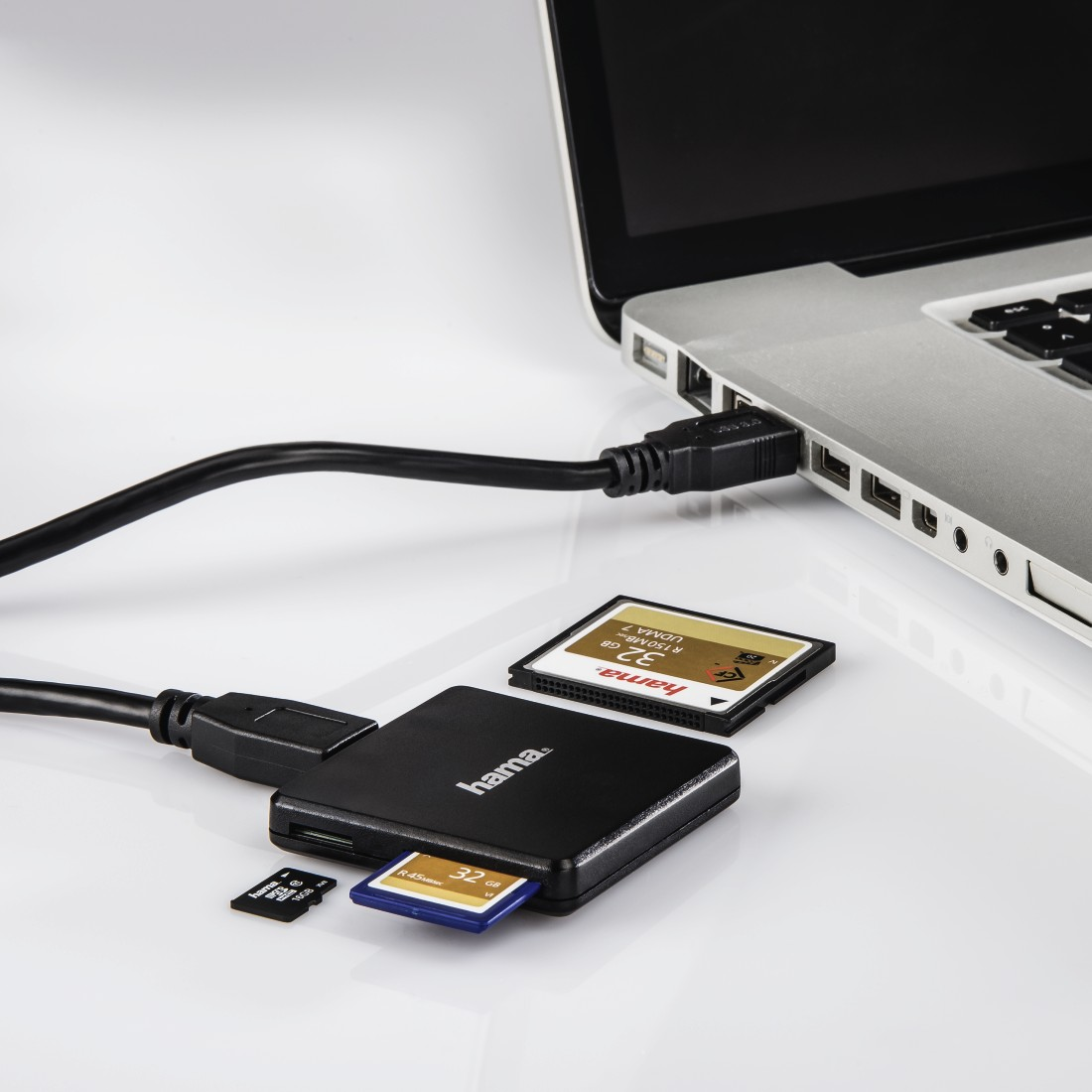 Speicherkartenleser mit Karten und Laptop, verbunden durch ein Kabel.