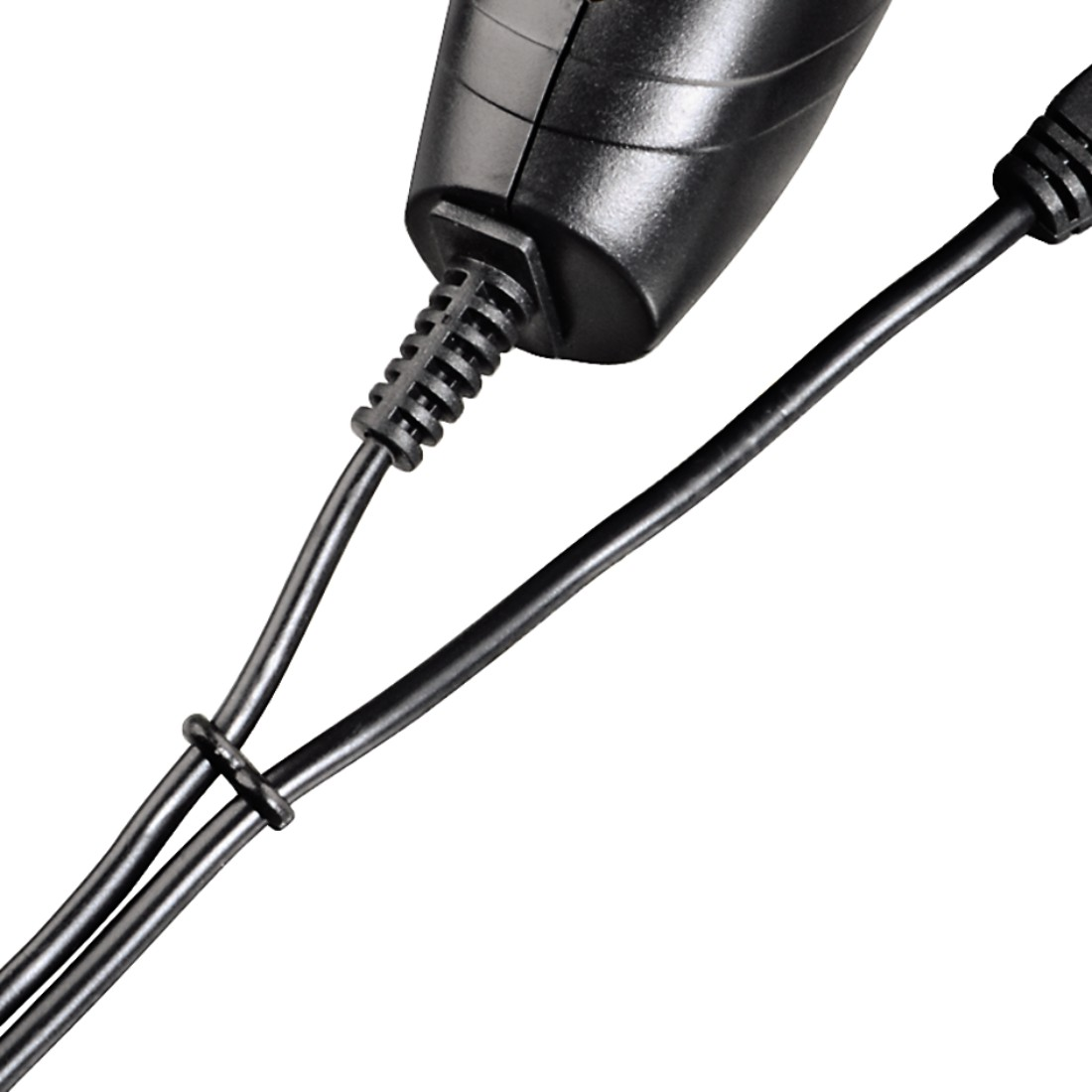 Nahaufnahme von schwarzen Kabeln, die an einen schwarzen Stecker angeschlossen sind. Die Kabel sind zusammengebunden.