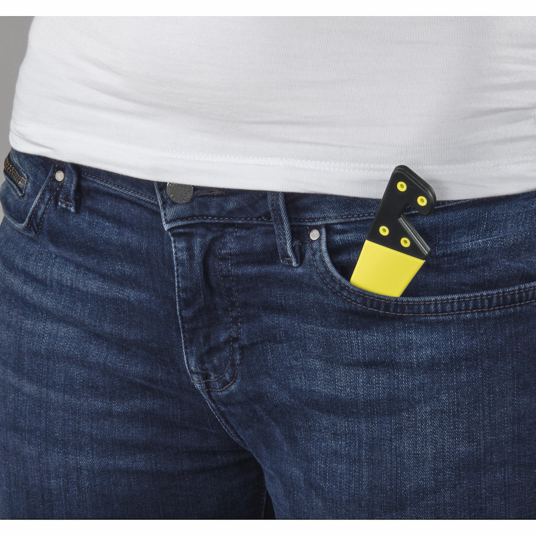 Ein gelb-schwarzes Werkzeug in einer Jeanstasche. Ein weißes T-Shirt und Jeans sind sichtbar.