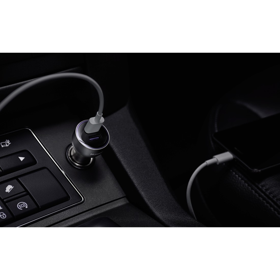 Autointerieur mit eingestecktem Huawei-Autoladegerät, das ein Telefon auflädt. Dunkle Umgebung mit Fokus auf Ladegerät.