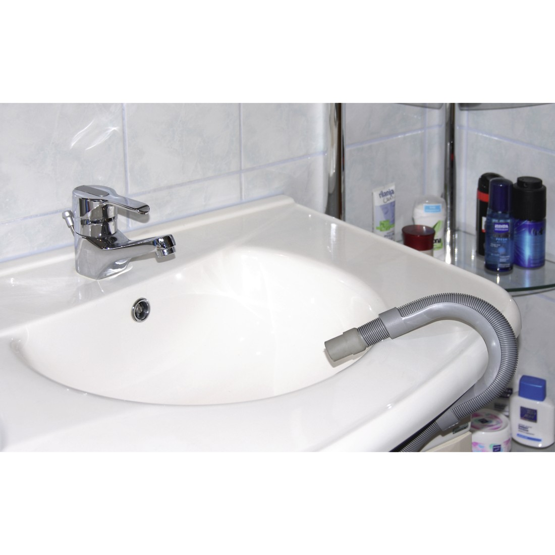 Weißes Waschbecken mit Chromarmatur. Ein grauer flexibler Schlauch liegt im Waschbecken.