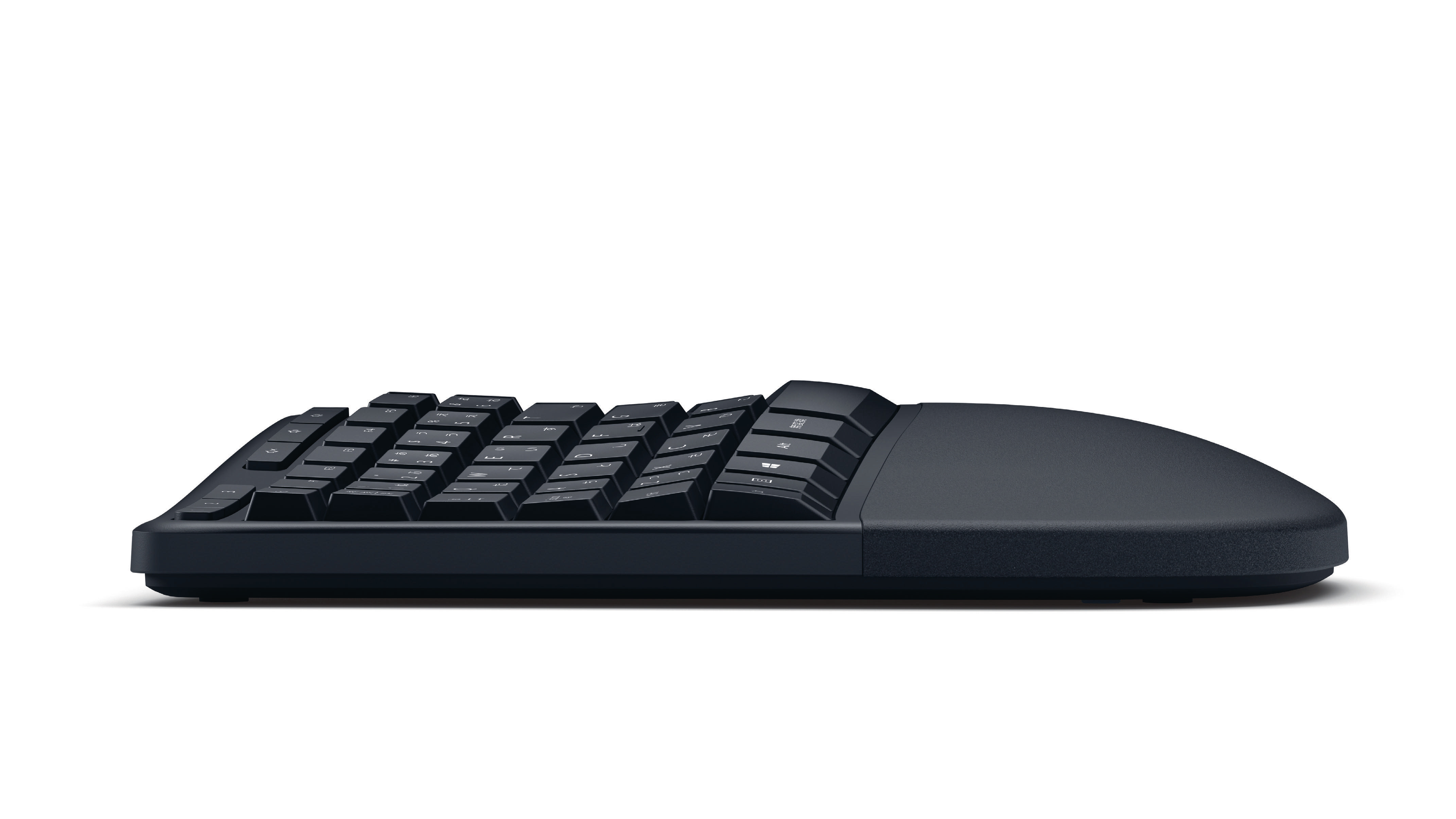 Schwarze ergonomische Tastatur, Seitenansicht, auf weißer Oberfläche.