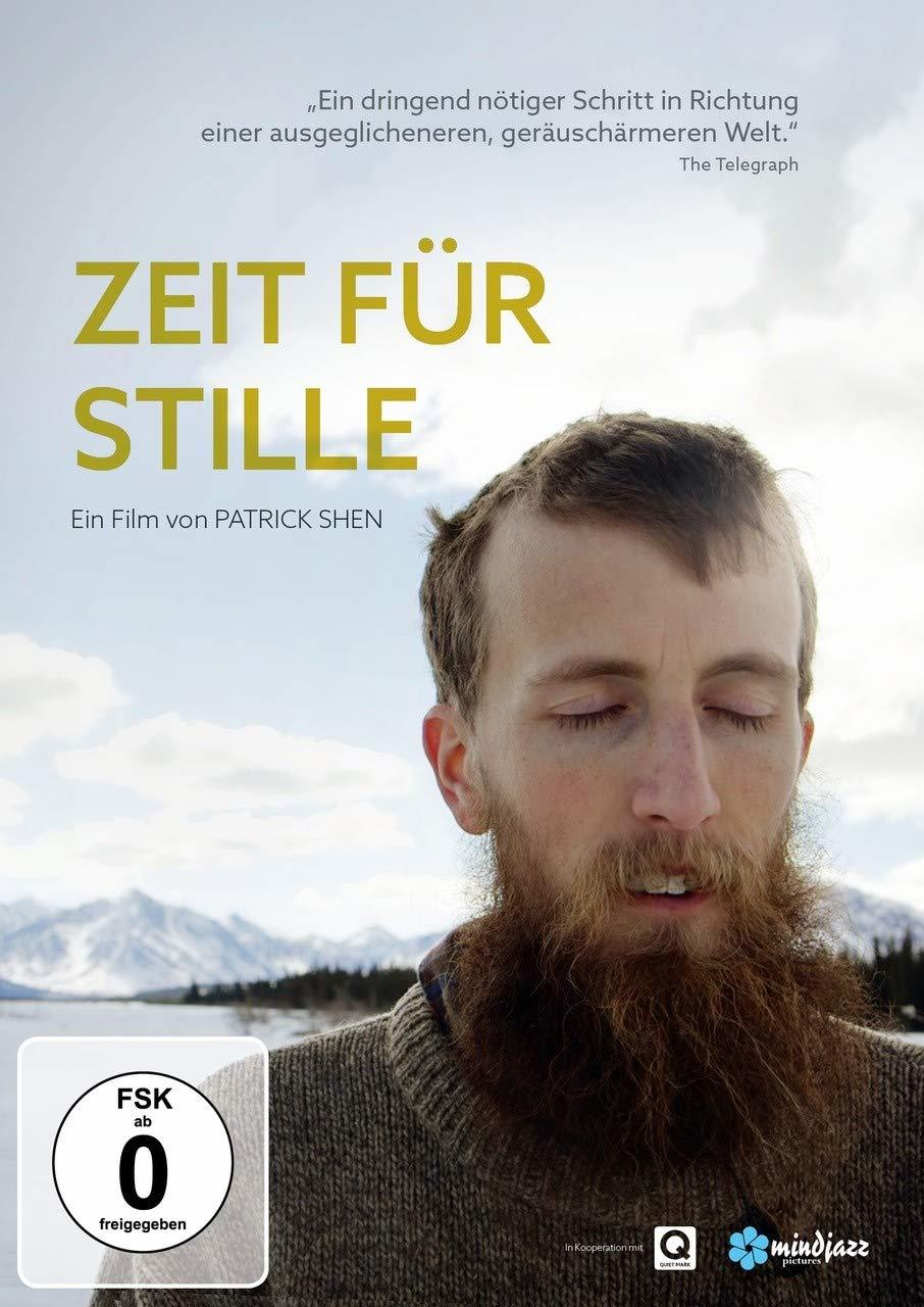 Filmplakat mit bärtigem Mann, geschlossenen Augen und dem Titel 'Zeit für Stille'. Im Hintergrund Berge.