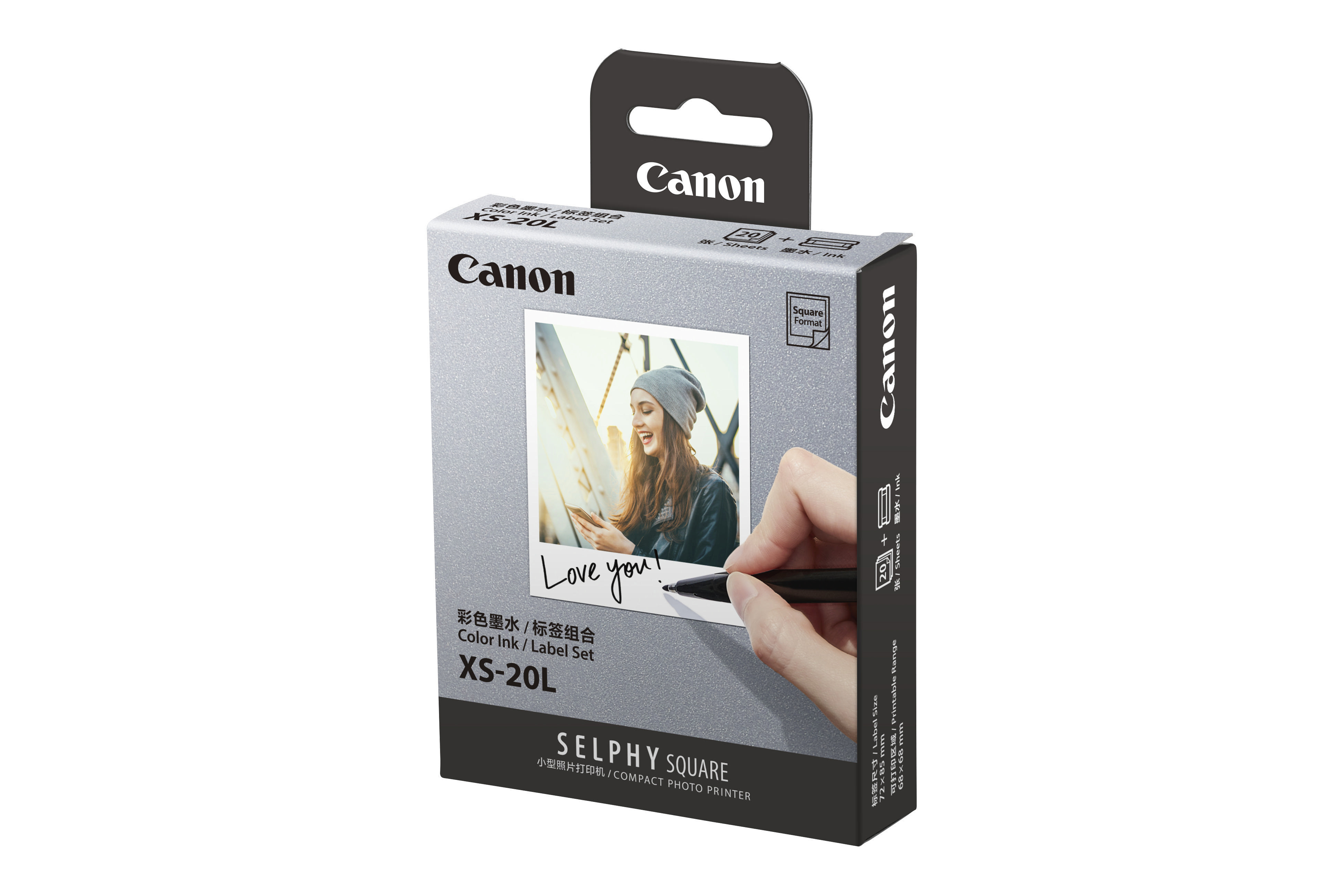 Eine Canon-Box für einen Drucker im quadratischen Format. Eine Person schreibt mit einem Stift auf ein Foto.