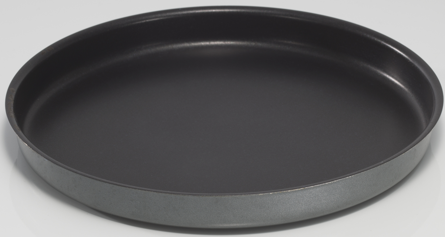 Dark gray, round pizza baking tray on a white surface, close up shot.