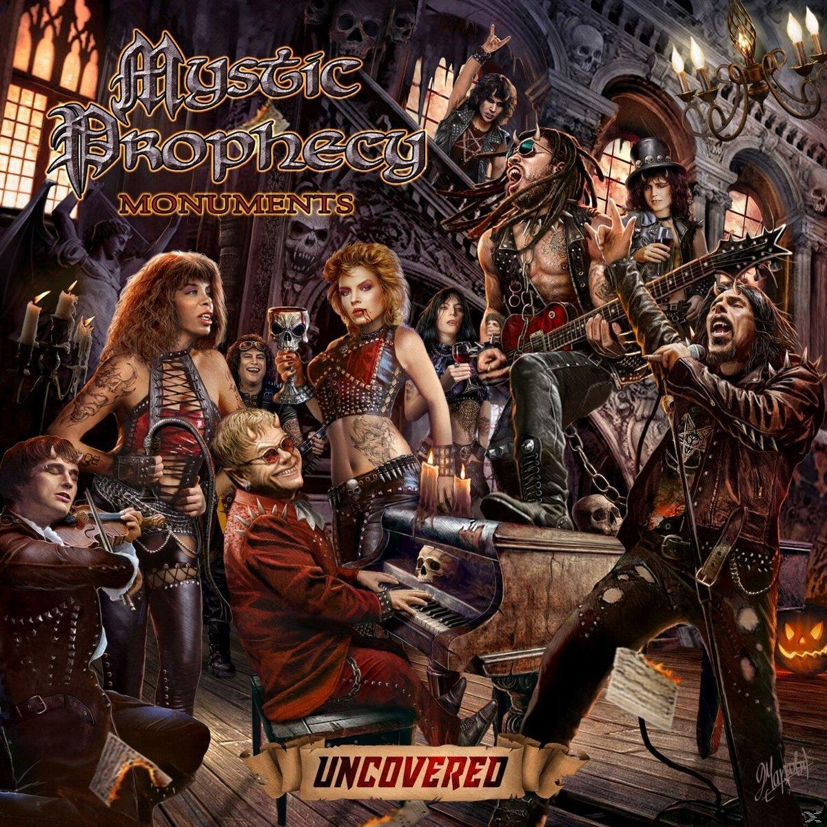 Albumhoes met een band die optreedt in een gotische setting. Muzikanten bespelen instrumenten. De titel luidt 'Mystic Prophecy Monuments Uncovered'.
