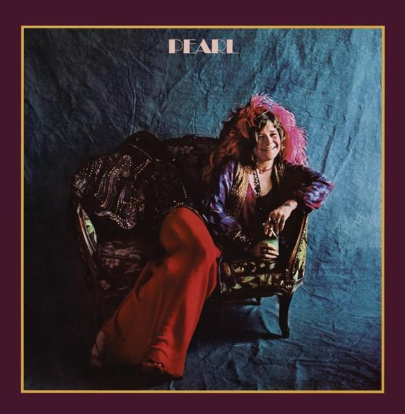 Janis Joplin auf dem Albumcover 'Pearl', auf einem gemusterten Sofa sitzend, in roter Hose. Lila und goldener Rahmen.