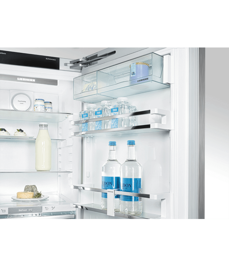 Open fridge shows shelves with bottles, jars, and food items. Lights inside, white interior.