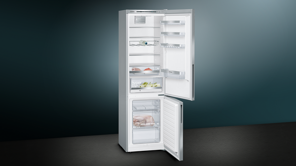 Ein Kühlschrank mit geöffneten Türen, der Regale und Inhalte vor dunklem blaugrünem Hintergrund zeigt.