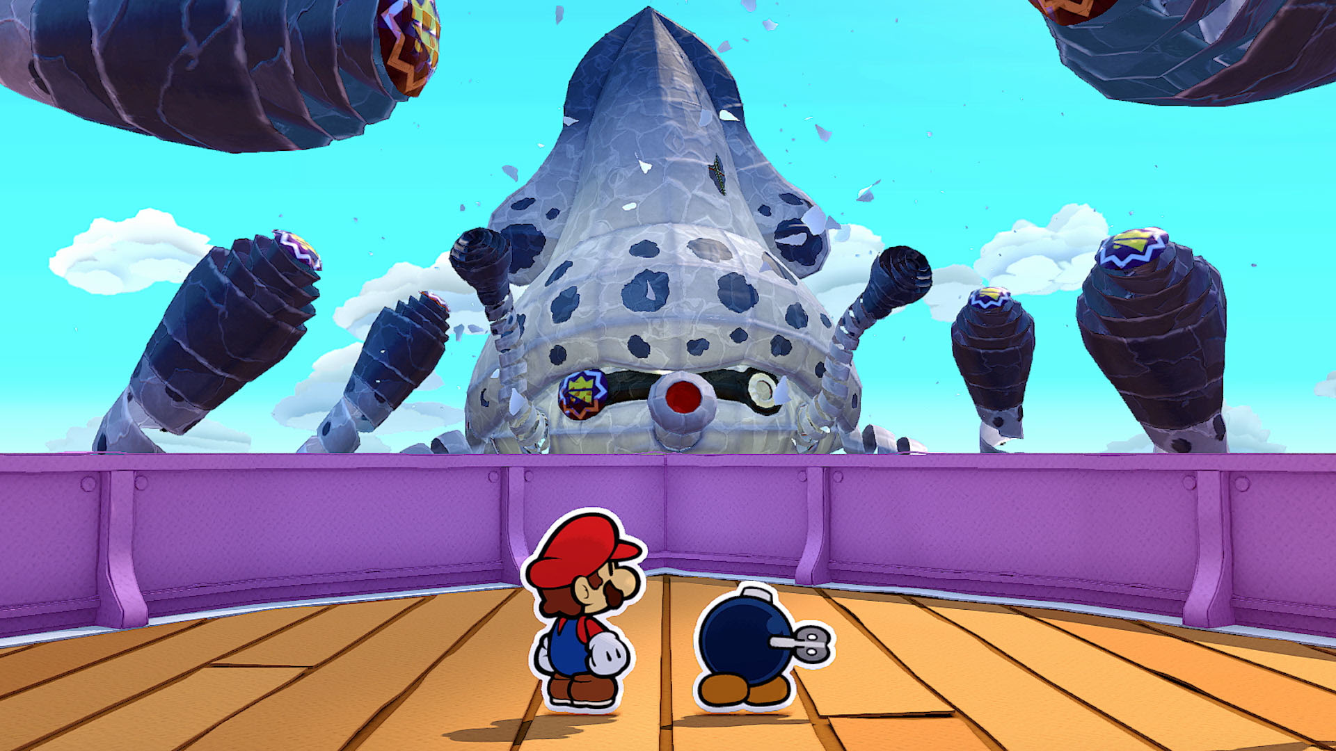Mario und eine Bombe stehen vor einem riesigen, grauen Wesen mit Objekten im Hintergrund.