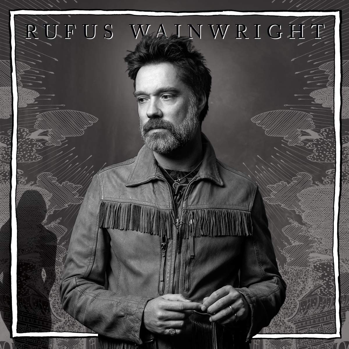 Rufus Wainwright, fekete-fehér fotó, dzsekit visel, és elnéz.