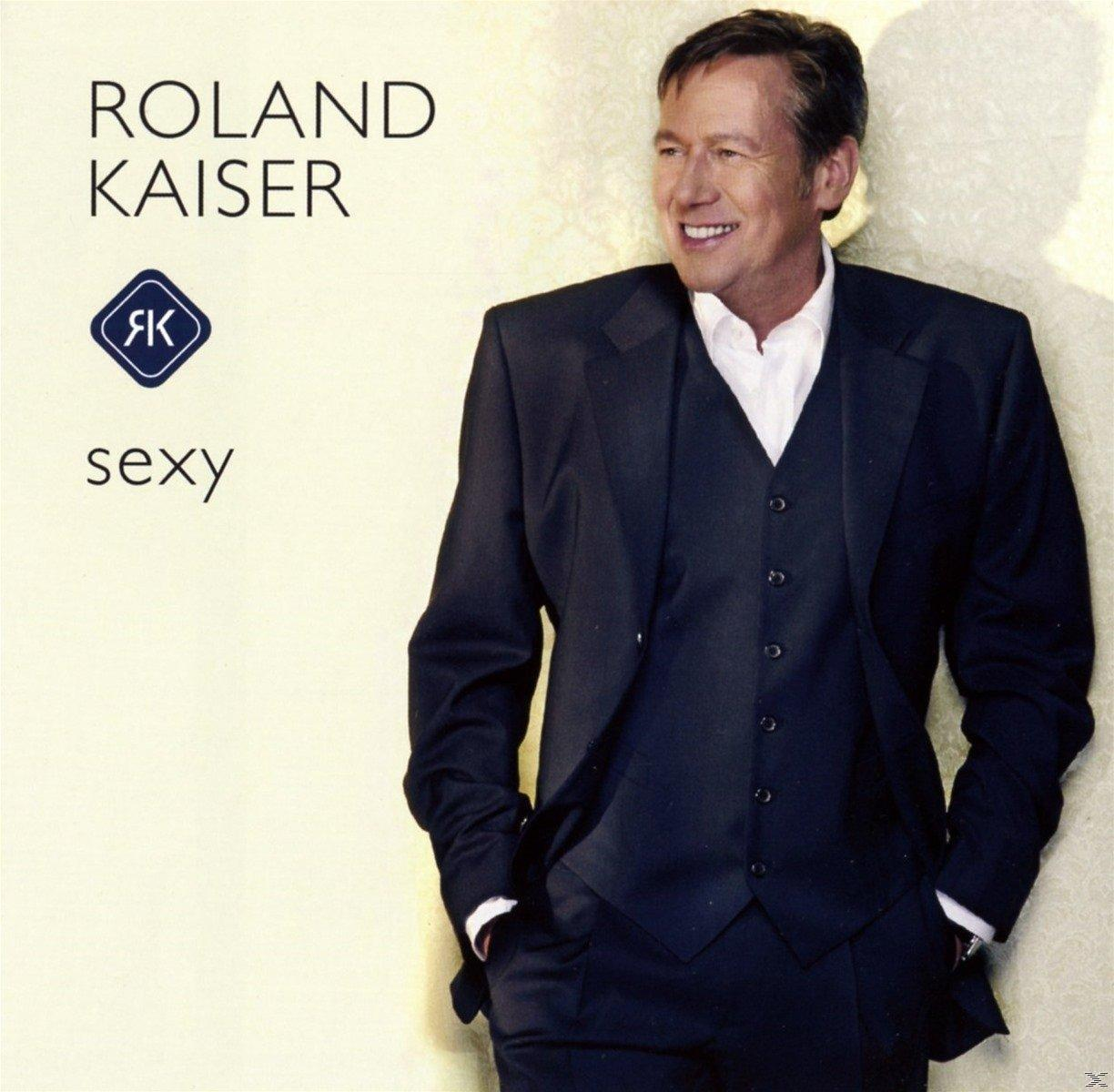 Albumcover mit Roland Kaiser, der einen Anzug trägt und lächelt. Text: Roland Kaiser, sexy, mit Logo.