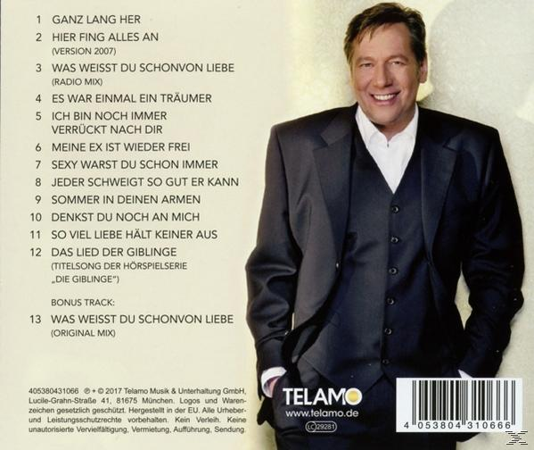 Rückseite einer CD-Hülle mit Text und einem lächelnden Mann im Anzug.