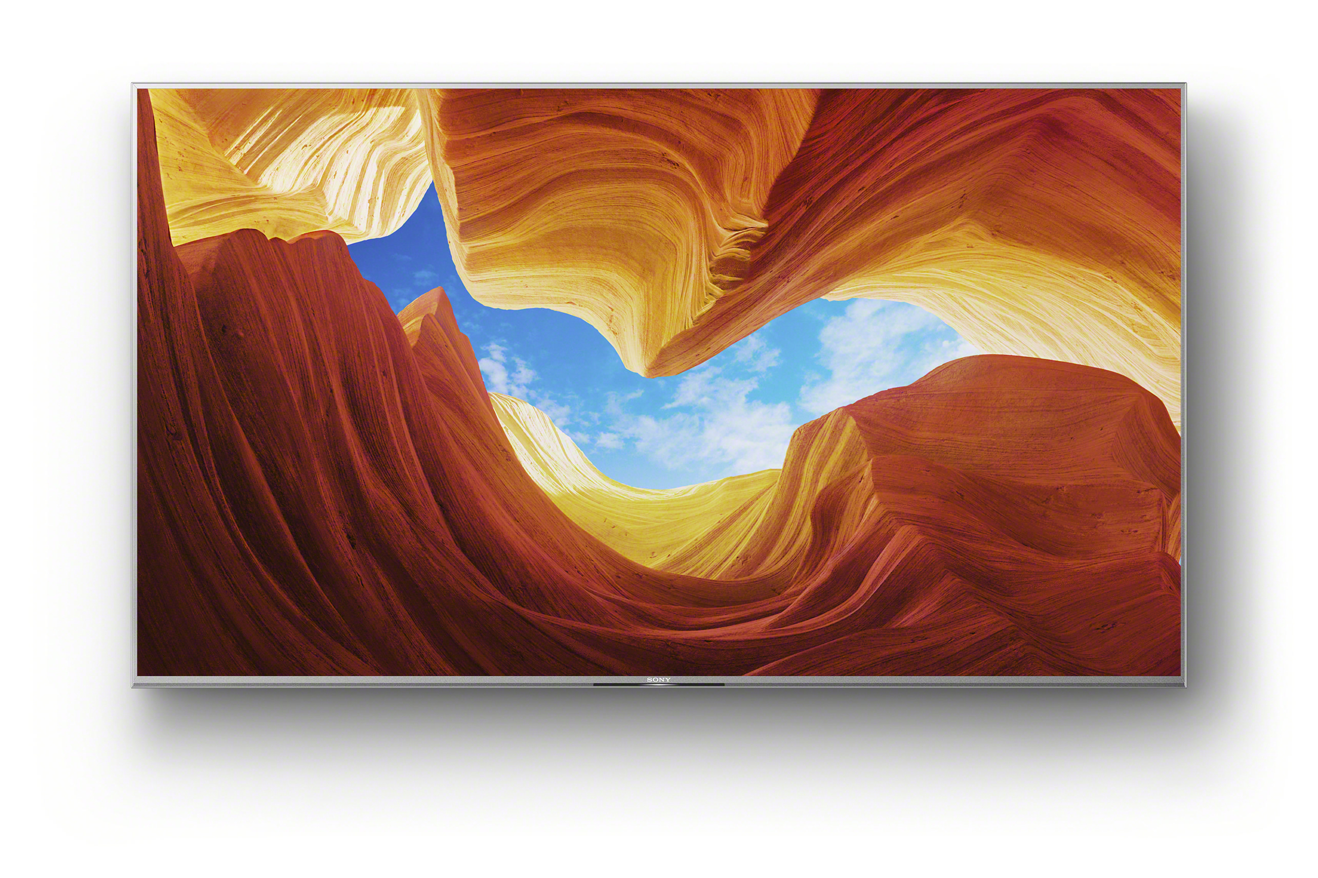 Großer Fernseher, der eine Wüstenlandschaft mit blauem Himmel und roten Felsformationen zeigt.