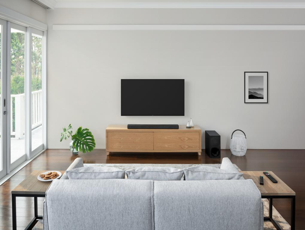 Una sala de estar con TV, sofá y mesa auxiliar.