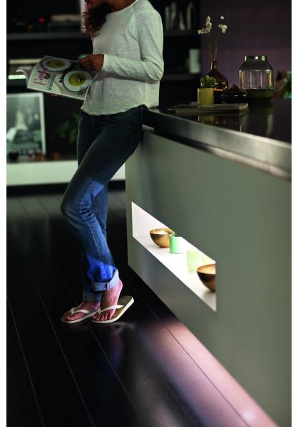 Una donna in cucina con una luce dall'alto.