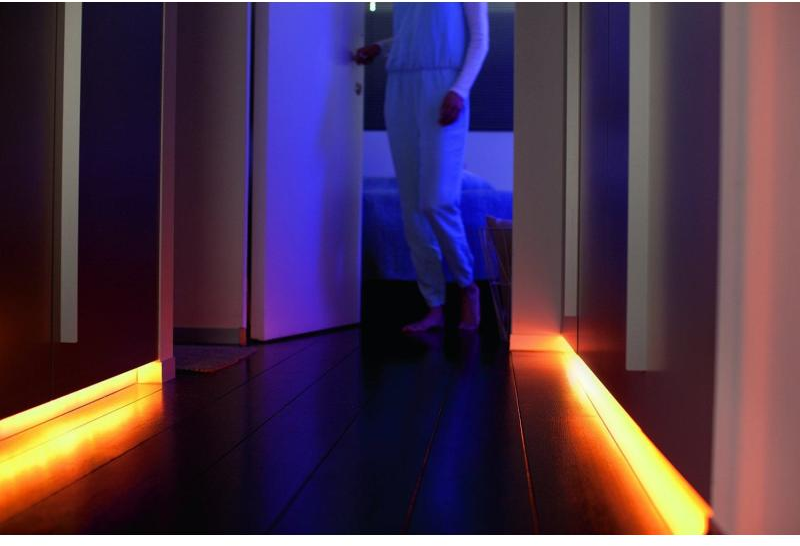 Persona in una porta con luce arancione che illumina il pavimento.