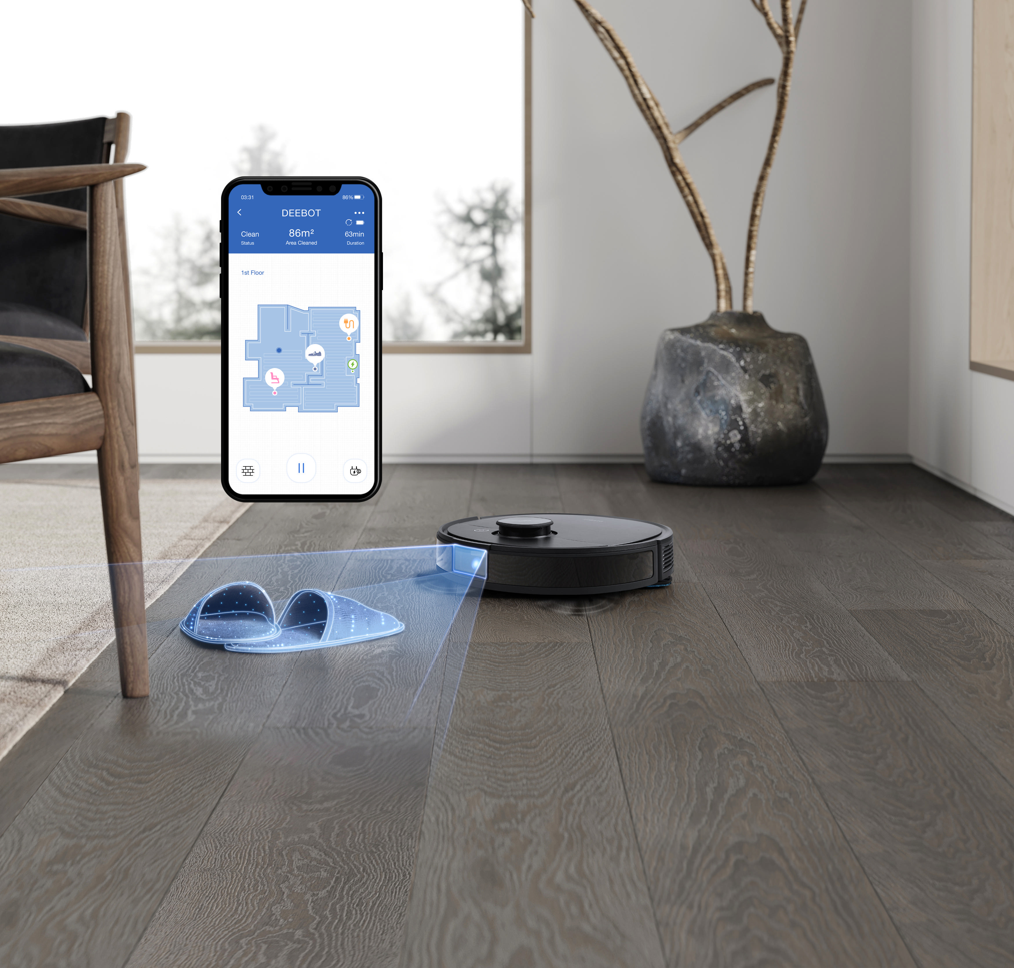 Ein schwarzer Roboter-Staubsauger auf einem Holzboden. Ein Telefon zeigt eine Karte des Raumes.