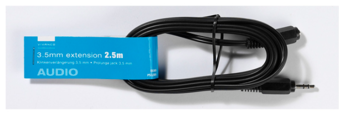 Ein schwarzes Audio-Verlängerungskabel ist um eine blaue Box gewickelt. Auf der Box steht '3,5mm Verlängerung 2,5m'.