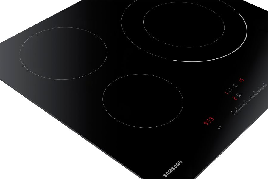 Una placa de inducción negra con tres zonas de cocción circulares y números rojos.