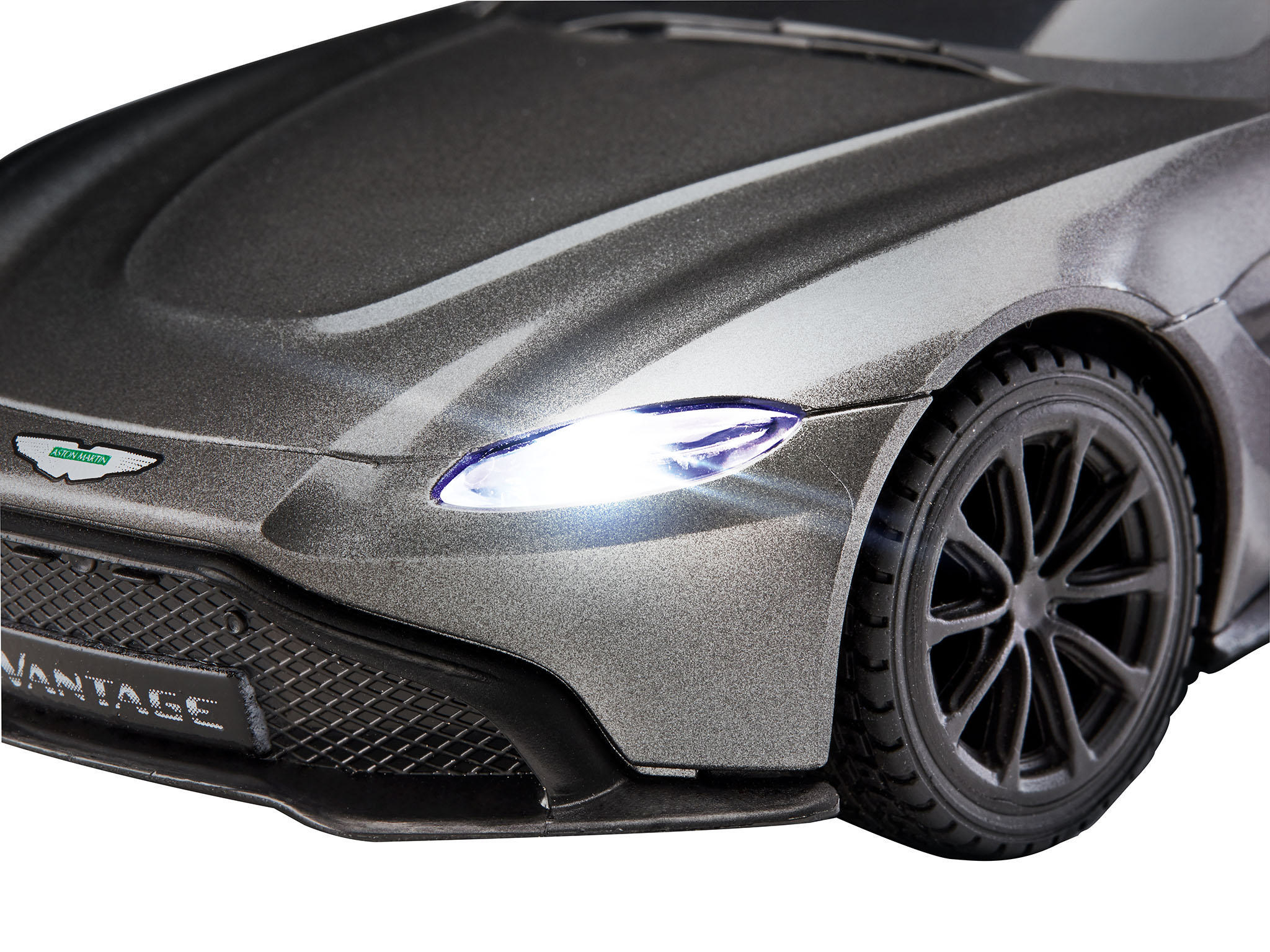 Nahaufnahme eines grauen Aston Martin Vantage Autos mit leuchtendem Scheinwerfer.