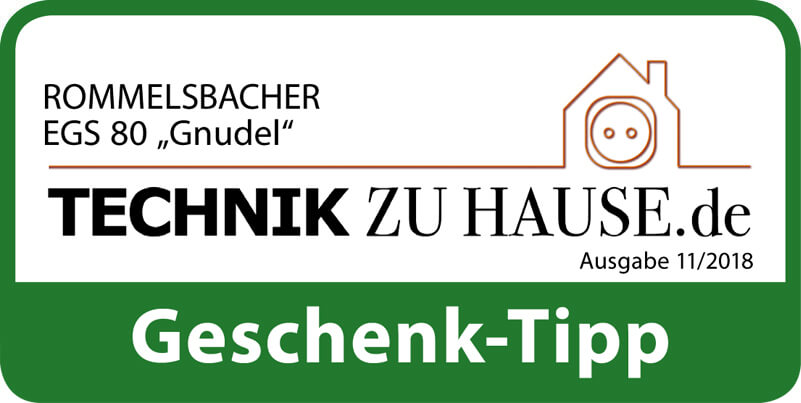 Ein grünes und weißes Abzeichen mit Text und einem Haussymbol, der Text lautet 'Geschenk-Tipp'.