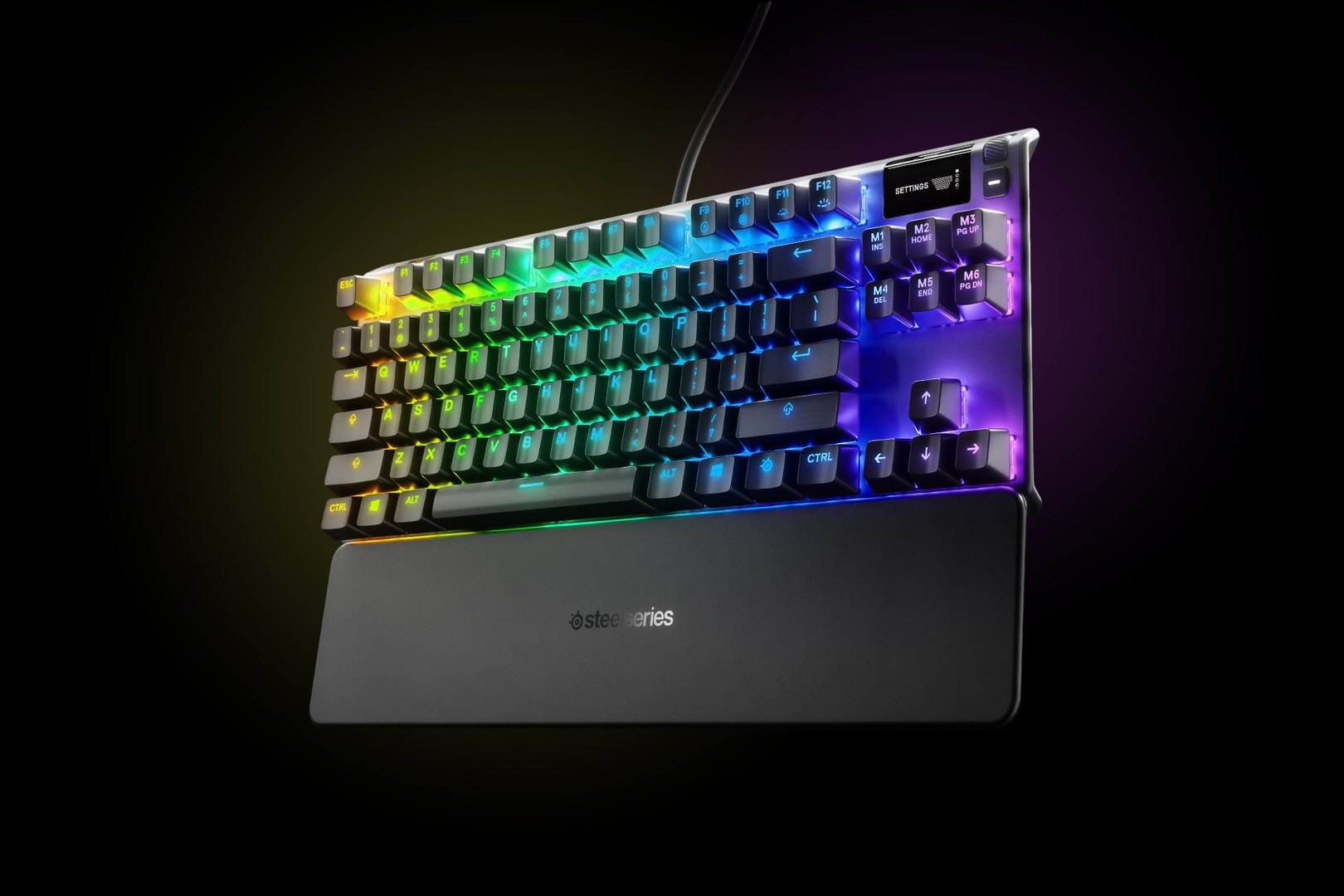 Háttérvilágításos gamer billentyűzet szivárványos világítással. Csuklótámaszt és a SteelSeries logót tartalmazza. A gombok feketék.