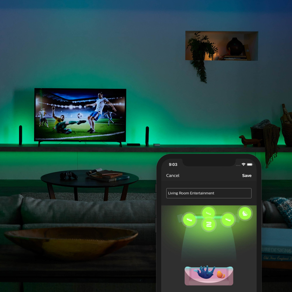 Woonkamer met tv, groene lichten en een telefoon met een bedienings-app.