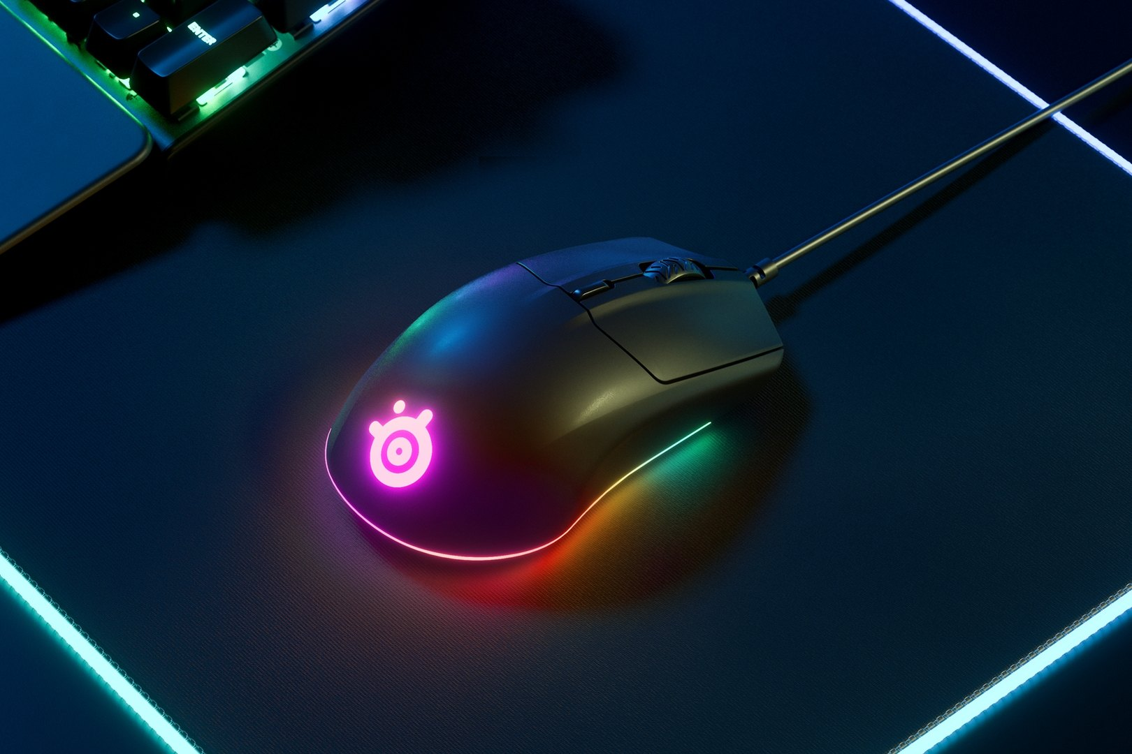 Fekete gaming egér fekete egérpadon, színes fényekkel. A SteelSeries logó világít.