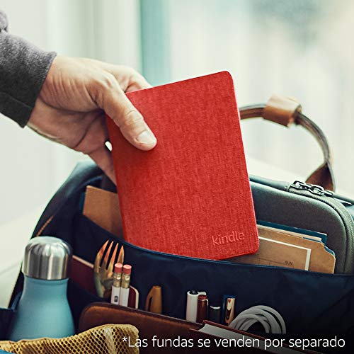 La mano de una persona sosteniendo un Kindle rojo en una bolsa con otros artículos de viaje.