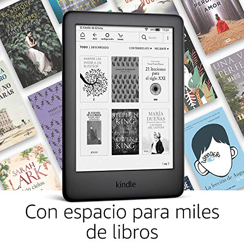Lector de libros electrónicos Kindle negro mostrando selección de libros. Libros al fondo.