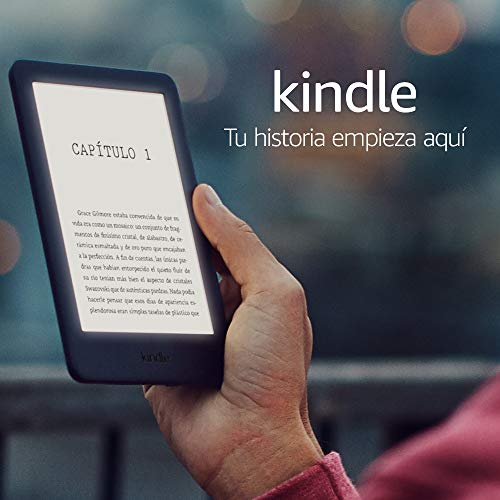 Una mano sostiene un Kindle. La pantalla muestra texto, con las palabras 'Tu historia empieza aquí'.