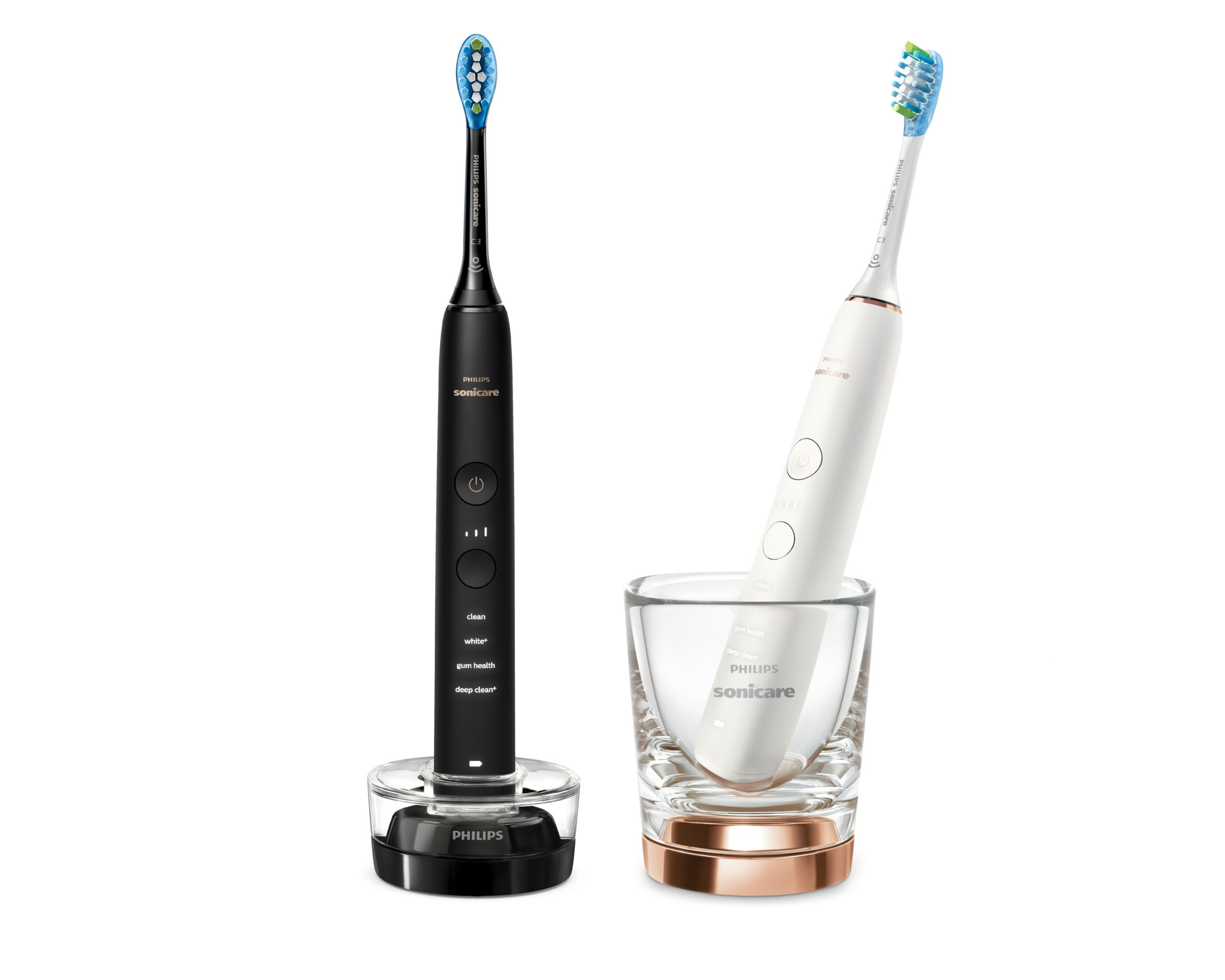 Zwei elektrische Philips Sonicare Zahnbürsten, eine schwarz, eine weiß, mit Ladestationen und Glas.