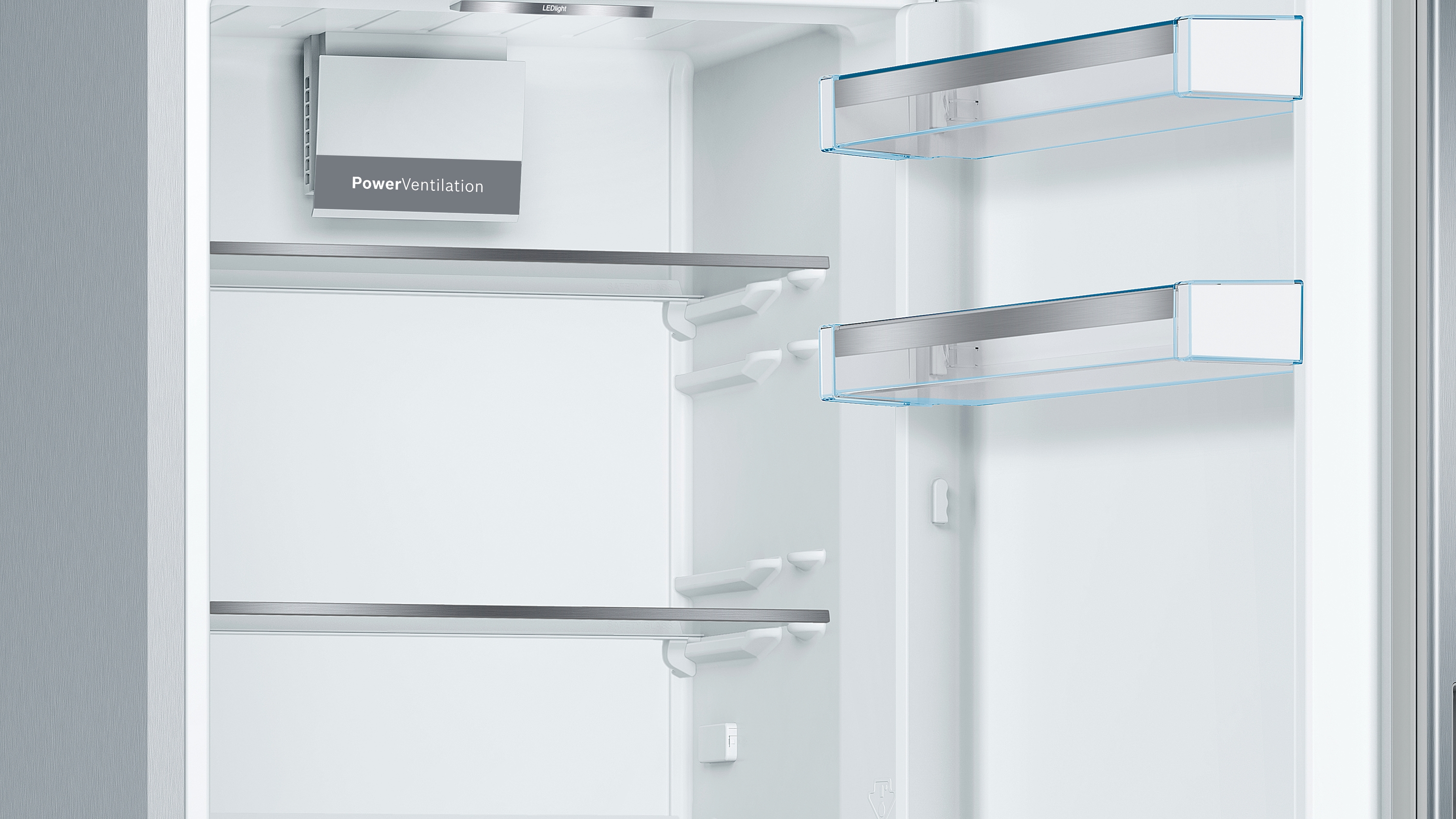 Ein offener Kühlschrank mit leeren Regalen. Die Wände sind weiß. Die PowerVentilation ist sichtbar.